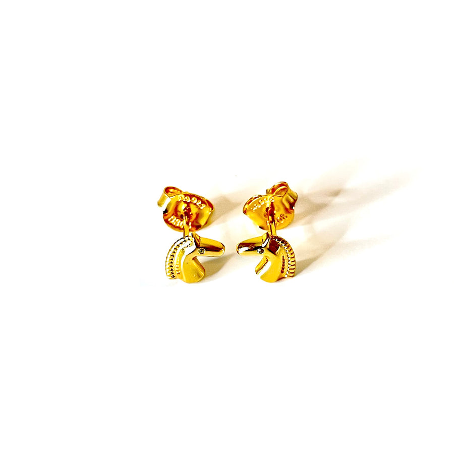 Pendientes de forma de caballo de plata de ley con baño de oro y circonitas turquesas. Son divinos para combinar con tu look diario.